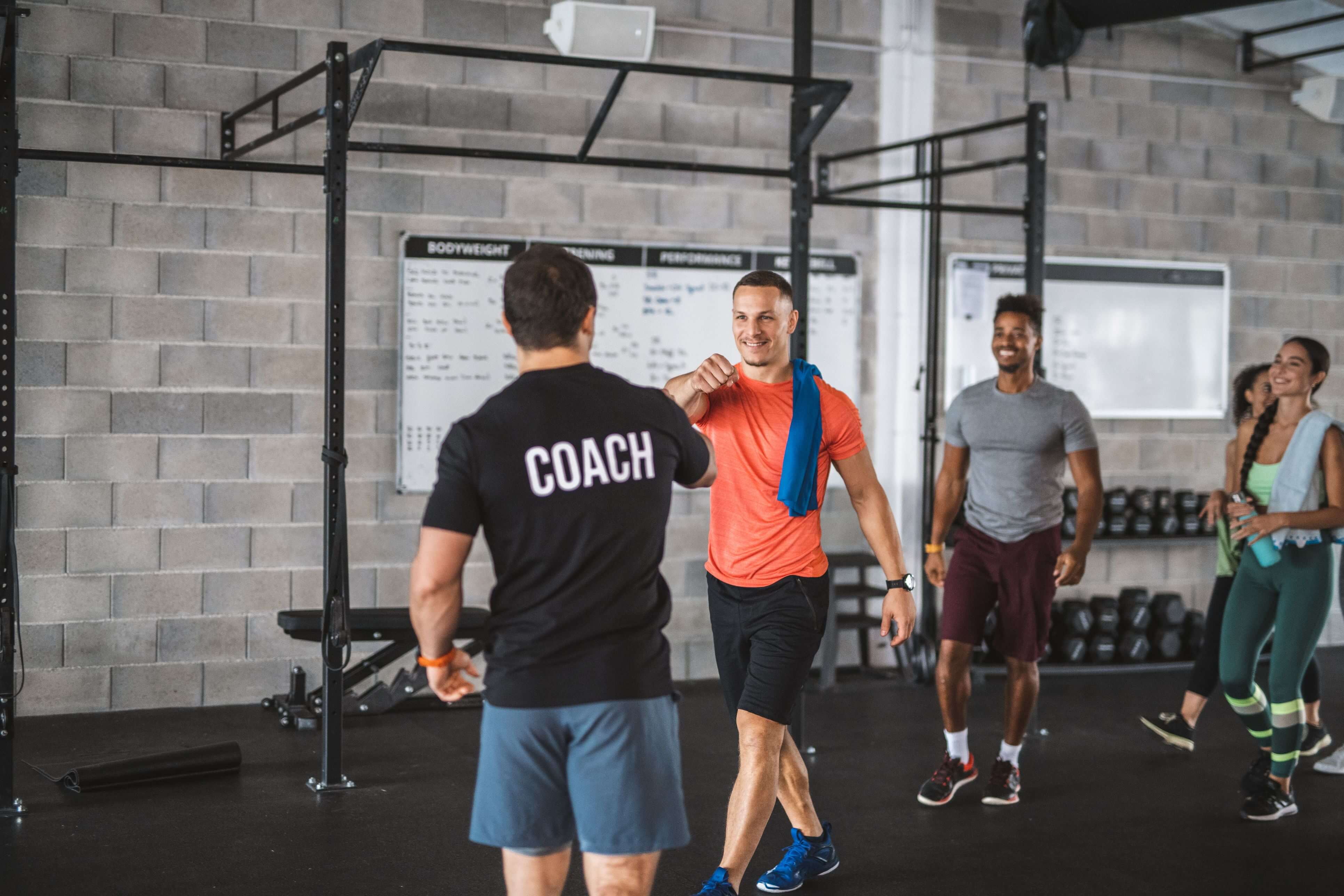 Personal trainer greeting clients in a rented gym